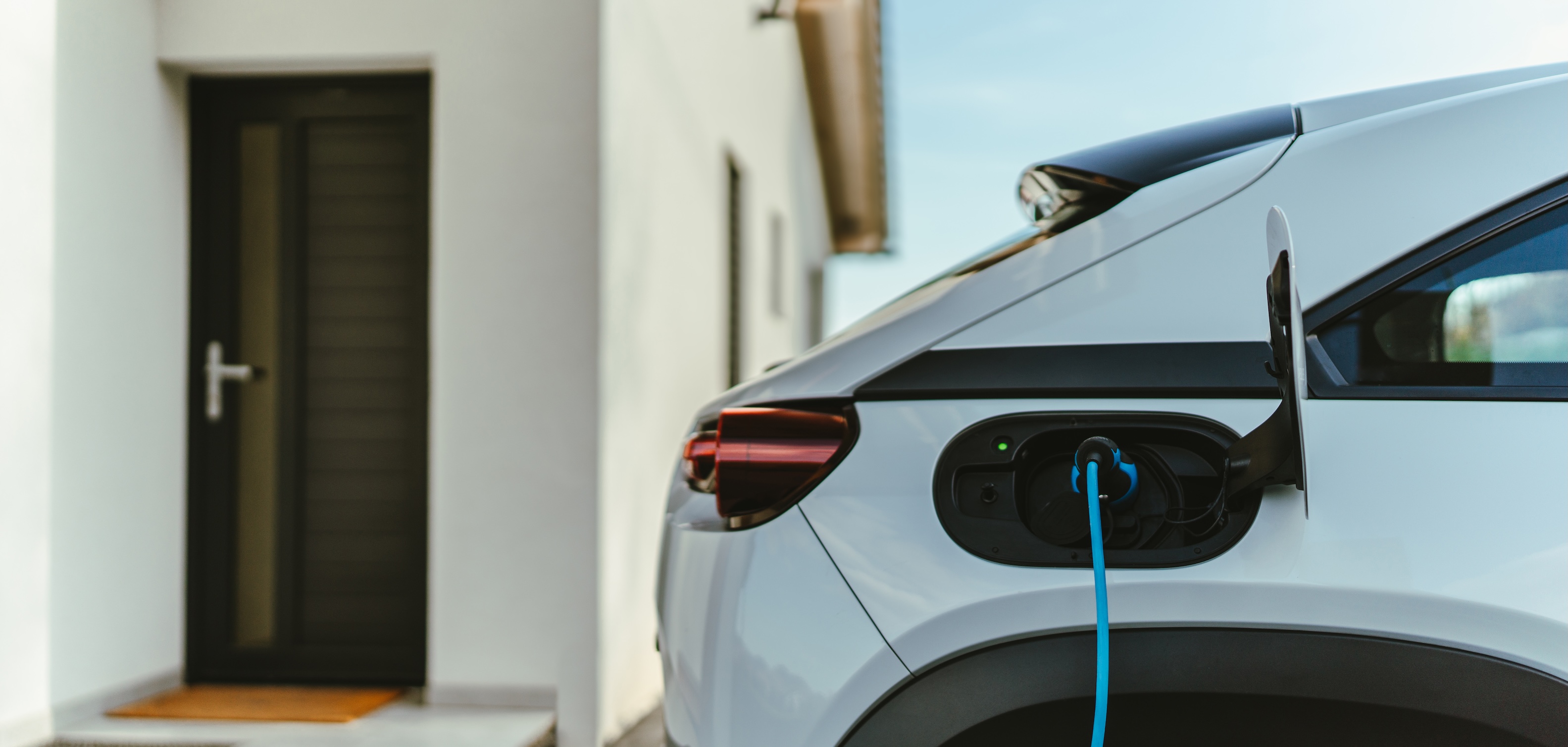 Close-up of an electric vehicle charging at a modern Florida luxury home, highlighting sustainable living and eco-friendly design.